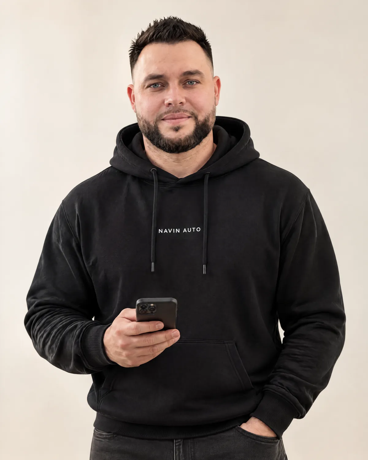 Макс Навин, основатель NAVIN AUTO, с телефоном в фирменном худи — аватар по реальным фотографиям